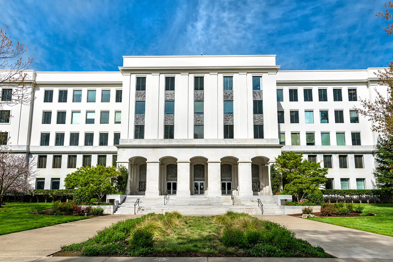 Sidewalk view of white government building